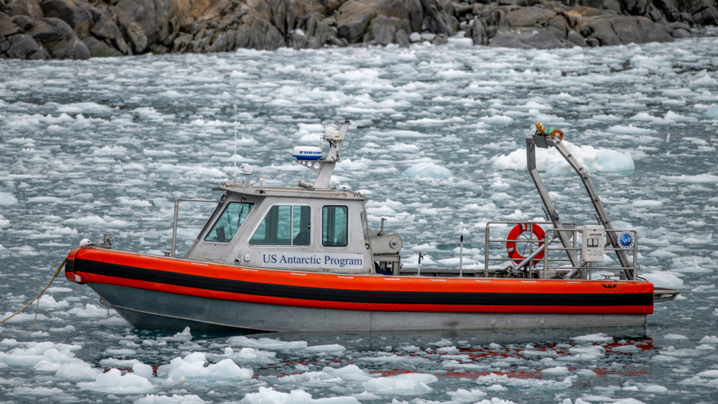 The small boat R/V Hadar in the harbor off Palmer Station Antarctica surrounded by sea ice.