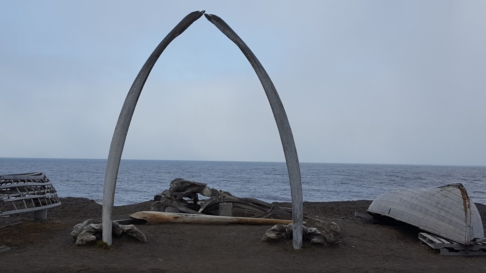 Whale bones and small boats setup along the coast of Alaska as a ceremonial site.